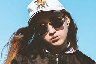 woman in black leather jacket wearing white cap and black sunglasses