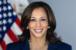 Official portrait of Vice President Kamala Harris with an American flag in the background.