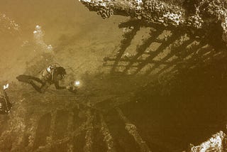 An illustration with a yellow overlay depicting divers exploring a sunken ship.