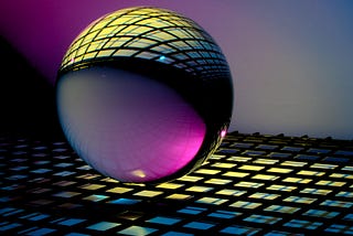 Coloured sphere over blue and white glass tiled surface