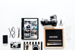 Photography gadgets arranged side by side on white surface.