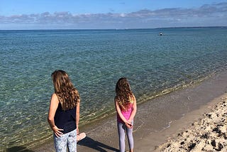 Two sisters at the beach on a sunny Sunday morning