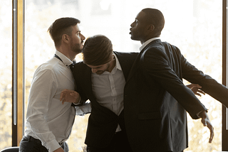 Three men in business attire. Two men around lunging at each other and the one in the middle is using his body to separate them. The article is Fighting in Corporate Speak Cheeky Email Responses Worth the Meeting with HR by Canopy Invocation.