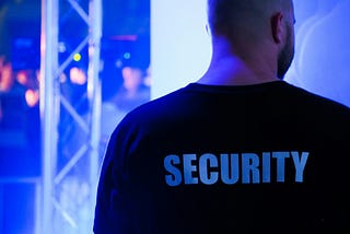 A big guy with his back turned and the word,”Security” printed on his shirt.