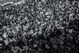 A black and white photo of a crowd of protesters sharing Black Lives Matter protest signs