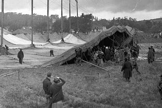 The tents spread out over night like white mushroom caps — more and more emerged each day of the…