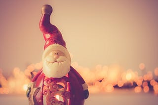 A figurine of a jolly Santa with a tall cap.