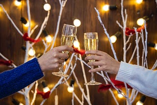 two people clinking champagne glasses, holiday background