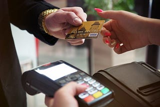 Person handing credit card to another person