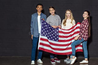 A group of American teenagers holding an American flag, about to take down the USSR. Image courtesy of Dreamstime, not actually depicting any of us.