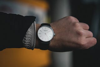 Man’s hand with an analog watch showing a time of 10:08