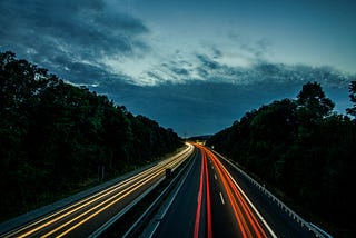 time-lapse photo of headlights and taillights on a highway at night