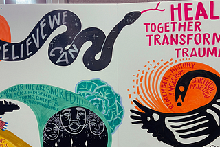 A white canvas displays a variety of hand-painted images including a black and white rendition of the Bono Adinkra symbol and a winding black snake. In white lettering, the snake’s body reads “believe we can,” and pink text by the snake’s head reads “heal together transform trauma.”