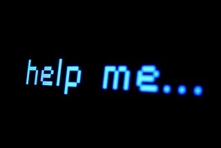 A black computer screen with only the words “help me…” written in blue, monospace font.