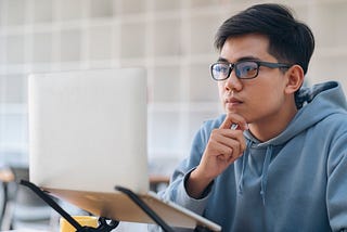 A boy reading from a laptop.