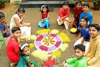 Kids making pookalam, an intricate and colourful arrangement of flowers laid on the floor during Onam days as part of the tradition. Souce: Internet