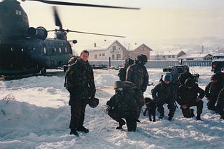 A photo of the author next to a helicopter in Bosnia.