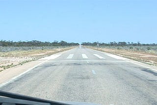 A road through the Australian outback with an emergency airstrip marked on it