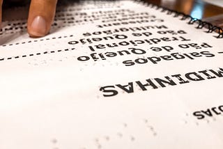 Anderson reads the restaurant’s Braille menu on the table. The menu also contains ink text in large letters.