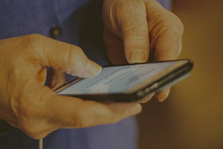 Someone textign on a phone, close up of just the hands and phone.