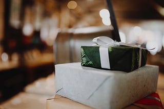 Two presents stacked on top of each other on a wooden table.