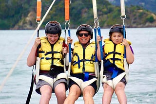 Mother and sons having a paragliding adventure together while unschooling.