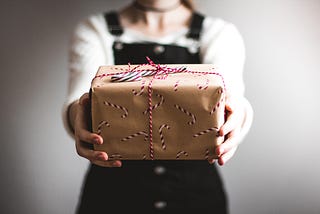 A gift wrapped package, handed out to you, by a delivery person.