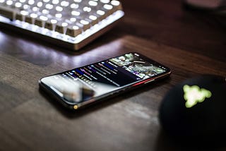 Smartphone on a table next to a computer keyboard