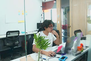 A picture of Milthon sitting in front of his desk while working.