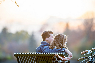 Couple holding each other on a bench