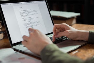 Hands typing on a laptop