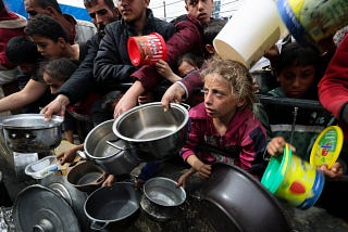 Hungry Palestinians including children hold empty bowls for scraps of food in Gaza this week.