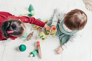 Two children playing with wood toys