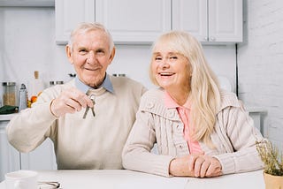 Senior elderly couple holding set of keys