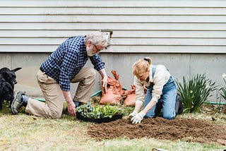 older married couple planting a garden near their house