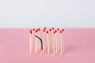 Several matchsticks standing up, with one burnt