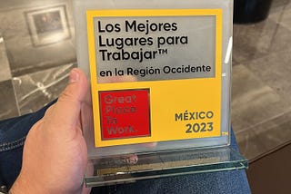 An unseen GrainChain team member holds our glass award, which says “Los Mejores Lugares para Trabajar en la Region Occidente,” Great Place to Work, and Mexico 2023.