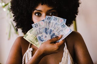 Woman holding money over her face