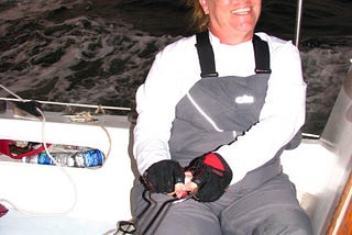 Dianne A Allen at the helm of a sailing yacht racing at sea.