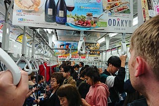 The back of my husband’s head as he looks into a packed Tokyo subway train