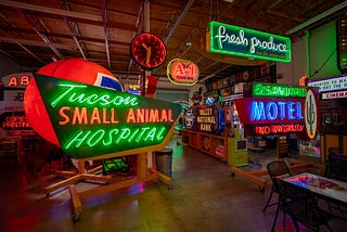 A collection of various neon signs in a darkened room at Ignite Sign Art Museum in Tucson, Arizona