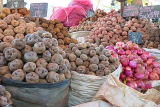 Different potato varieties on onions for sale at a market in Peru
