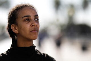 Dr. Timnit Gebru, wearing a black turtle neck and looking off to the side.