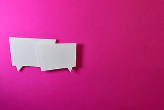 Two speech bubbles against a pink background