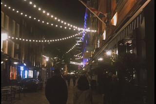 A couple walking on streets surrounded by lights