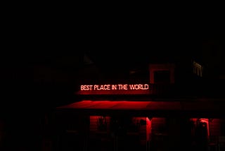 Neon sign saying “Best place in the world.”