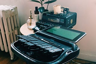 A modern Stenograph machine with an antique steno machine in the background.