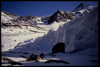 Jasper Smith sitting on a snow capped mountain mid climb during his Australia to Alaska expedition