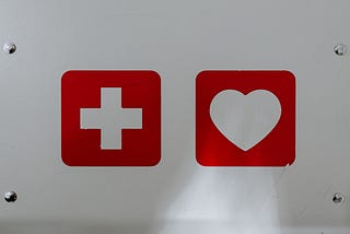 image shows a white medical cross on a red background and a white heart on a red background