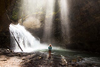 Woman near a frothy waterfall.